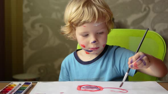 Young Boy Is Painting On White Paper