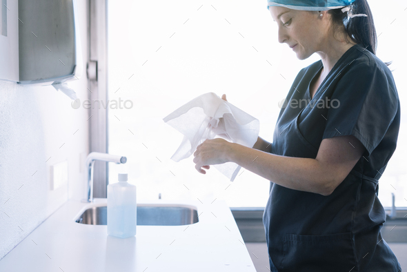 Female doctor washing hands before operating
