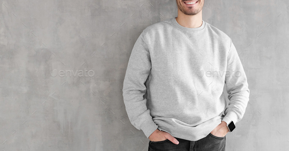 Mock up of young man body in empty sweatshirt isolated on textured gray wall background