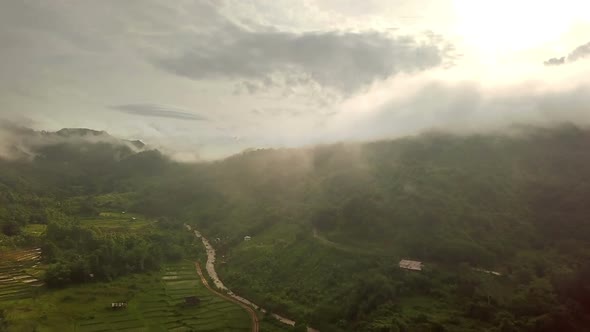 Aerial view of lush green tropical rain forest mountain with rain cloud cover during the rainy seaso alt