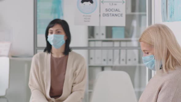 Sick Woman in Mask Coughing in Medical Office alt