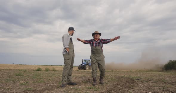 Happy Senior Farmer Showing Field To Grandson alt