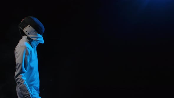 Side View of Young Guy Swordsman Putting on Protective Mask Helmet alt