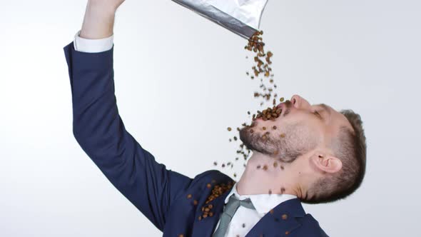 Sleep-Deprived Businessman Pouring Coffee Beans into his Mouth alt