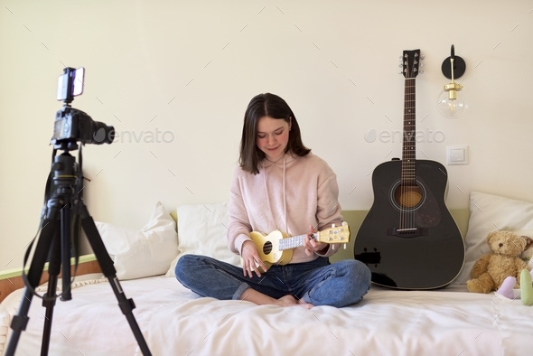 Teen girl playing on ukulele. Blog, music channel, vlog,