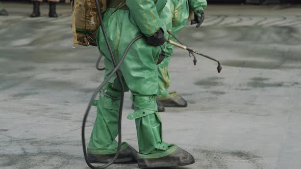 Workers in Bio Viral Hazard Protective Suits Disinfects Floor and Surfaces From Coronavirus alt