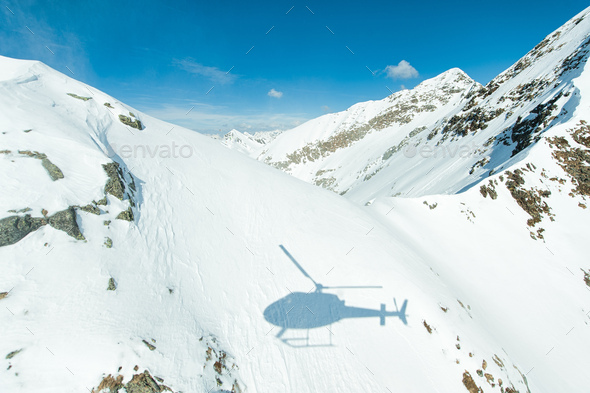 Helicopter shadow projected onto snow on mountains - Stock Photo - Images