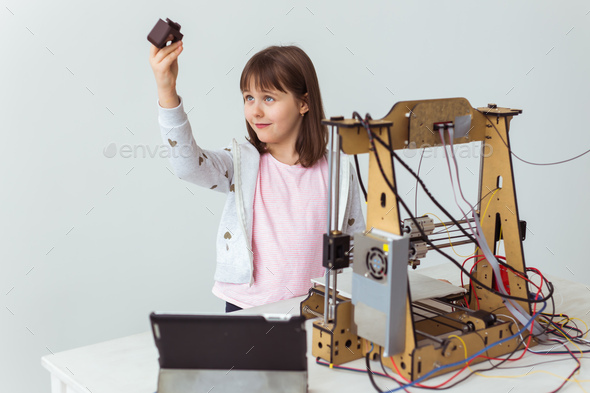 Child student makes the item on the 3D printer. School, technologies and science concept