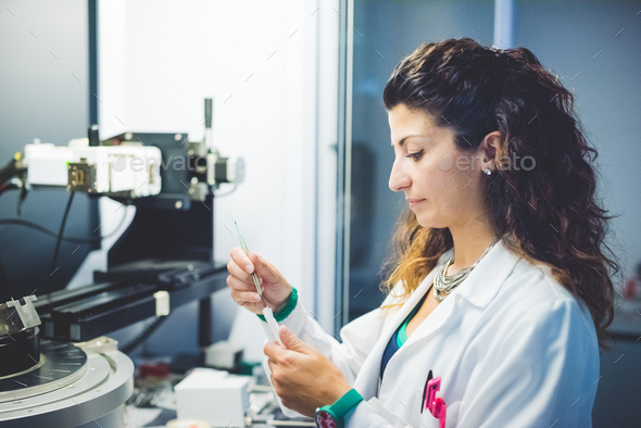 Female scientist preparing thin film sample for measurement with x-ray diffractometer