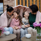 Two happy sisters with mother and grandmother sitting wrapped in blanket outdoors in patio in autumn - PhotoDune Item for Sale
