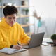 Asian man sitting at desk, using pc writing in notebook - PhotoDune Item for Sale