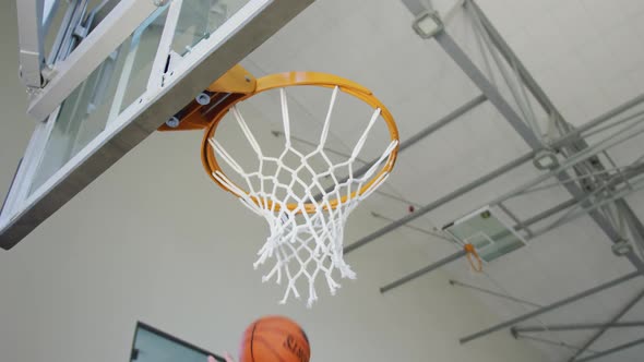 Caucasian male basketball player scoring goal during match alt