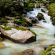 Blurred image of beautiful stream of water flowing over mossy rocks - PhotoDune Item for Sale
