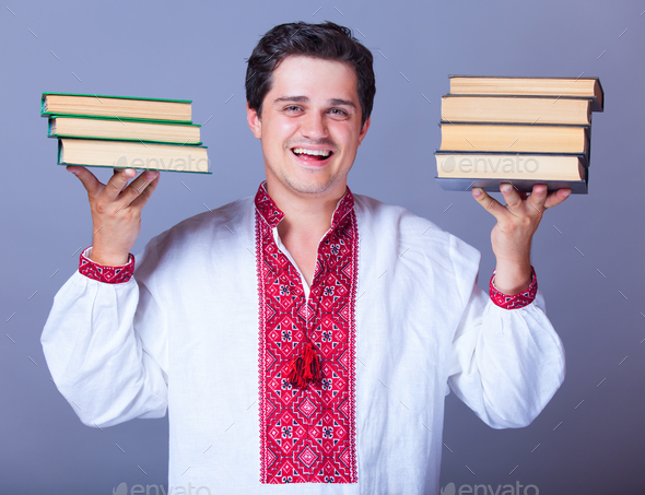 Man in embroidery shirt with books. - Stock Photo - Images