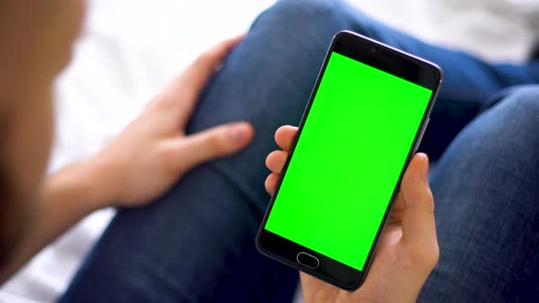 Black Smartphone with Green Screen for Chroma Key Compositing the Hands of a Man on Laptop alt