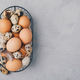 Eggs. Raw organic farm chicken and quail eggs in basket on gray stone background - PhotoDune Item for Sale