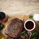 Concept of tasty food with beef steaks on wooden background - PhotoDune Item for Sale