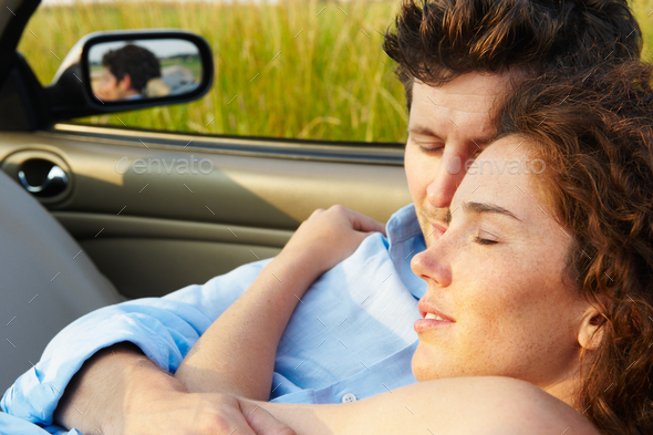 Couple laying in a convertible - Stock Photo - Images