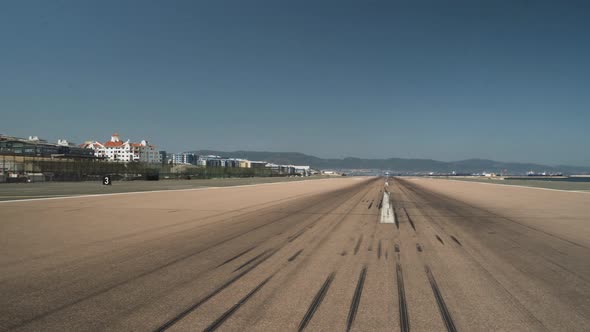 Empty runway tarmac with tire marks at Gibraltar airport, panning shot. alt