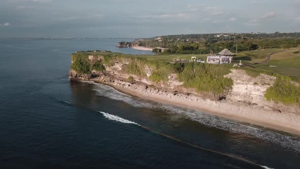 Aerial Footage of the Beach and a Big Cliff with a Wedding on Top of It