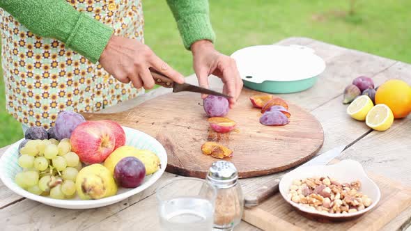 Woman cutting plum outdoors alt