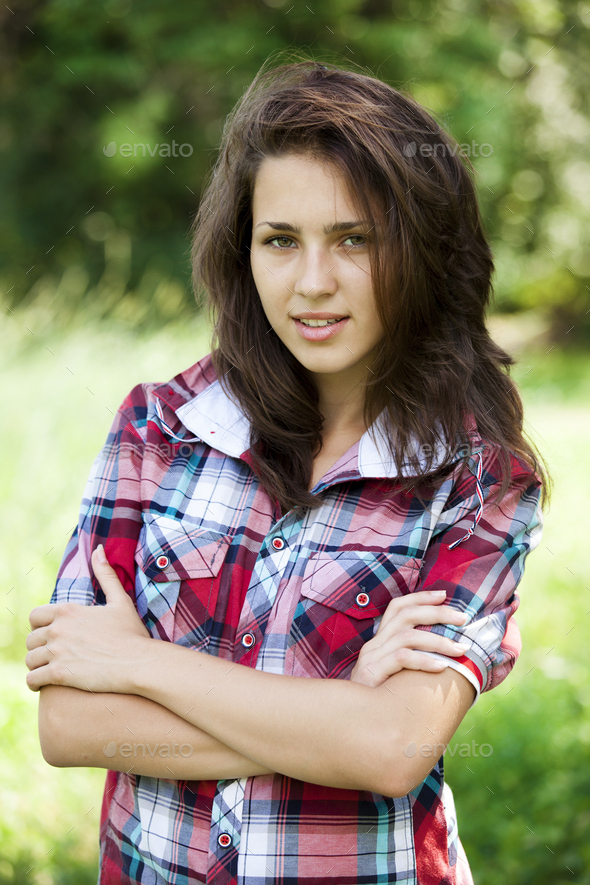 Beautiful teen girl in the park at green grass. Stock Photo by Masson-Simon