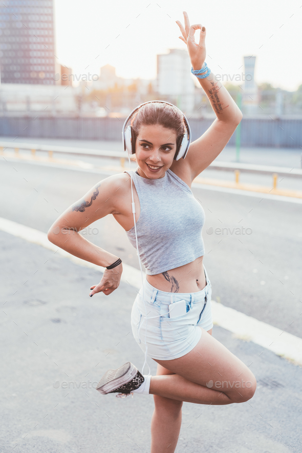 young beautiful multiethnic woman listening music with head phones - Stock Photo - Images