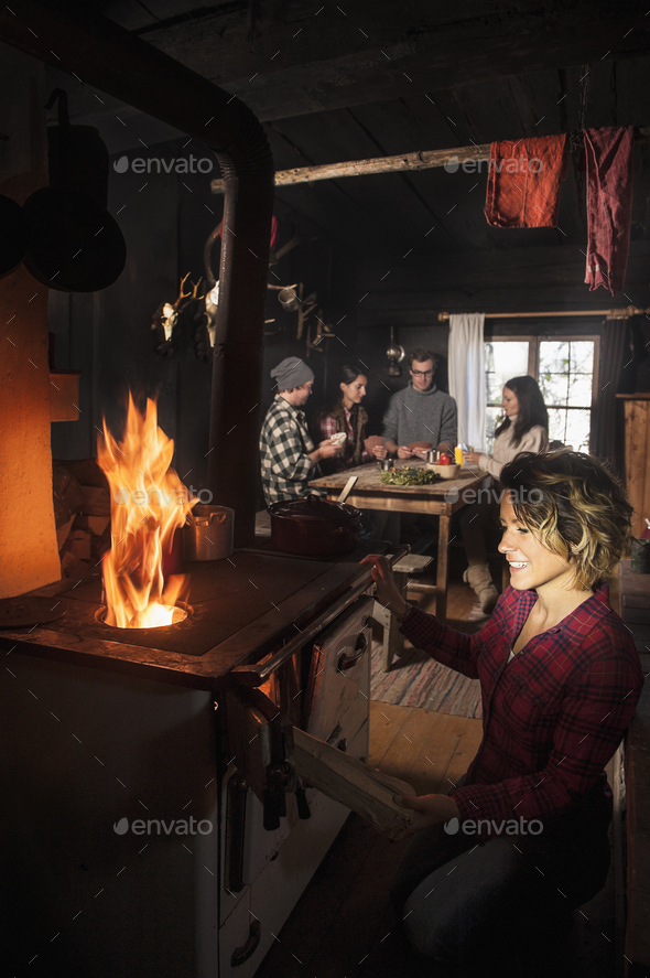 Group of young people in mountain hut with oven