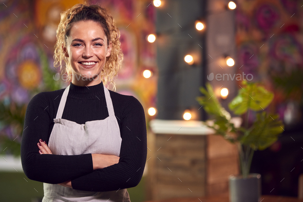 Portrait Of Smiling Female Server Working Night Shift In Bar Restaurant Or Club