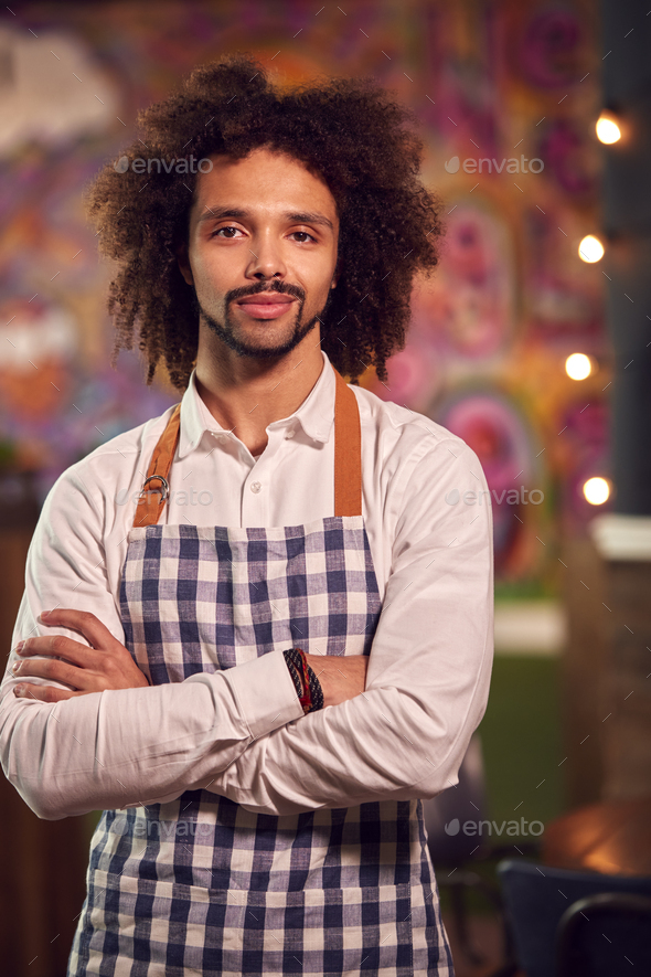 Portrait Of Smiling Male Server Working Night Shift In Bar Restaurant Or Club