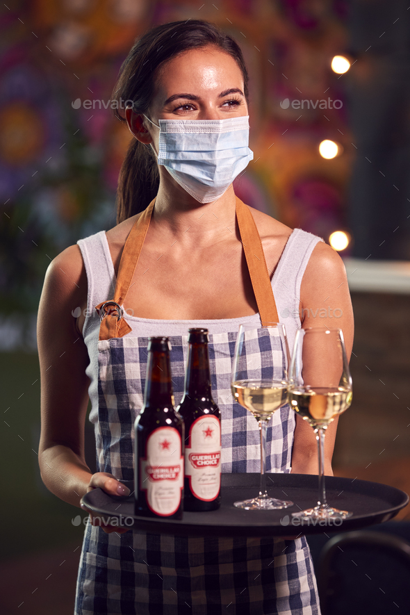 Portrait Of Female Server Wearing Face Mask Holding Tray Of Drinks In