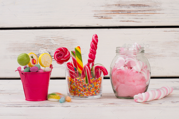 Glass jars with colorful candies, lollipops and gum balls.
