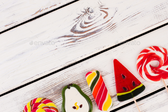 Delicious lollipops on wooden background.