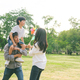 Happy Asian family playing with wind turbine together at a park - PhotoDune Item for Sale