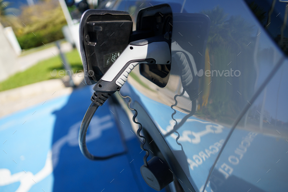 Refueling an electric car, an environment friendly alternative - Stock Photo - Images