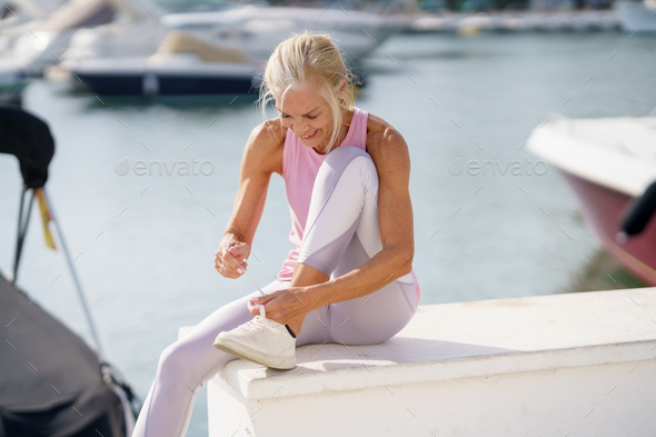 Senior woman tying shoelace and getting ready for fitness. - Stock Photo - Images