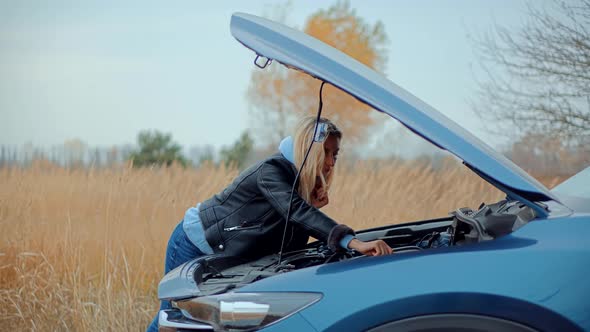 Auto Failure Accident Inspection Oil Level. Frustrated Girl Repairing Damage Car. Open Hood Motor. alt