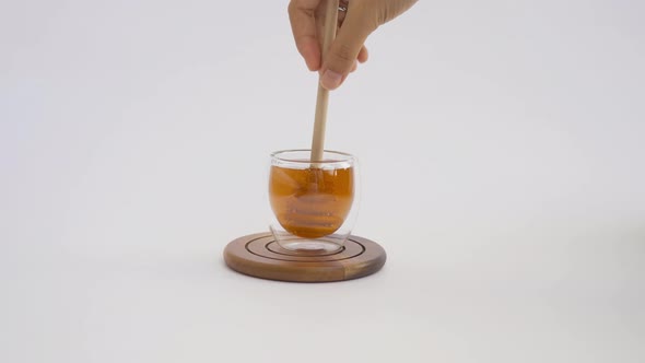 Honey with wooden dipper stick isolated on white background. Sweet food. Honey bees and wax. Nectar. alt