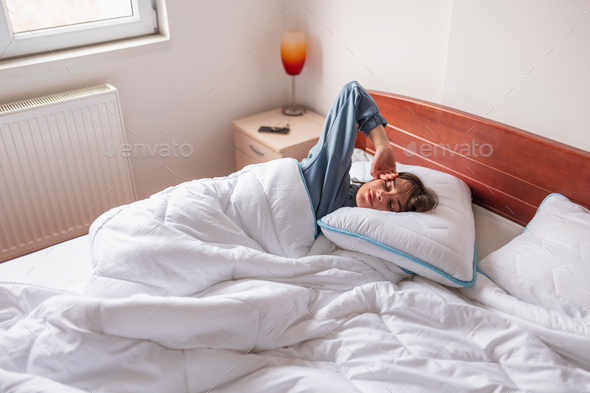 Woman waking up in bed in the morning
