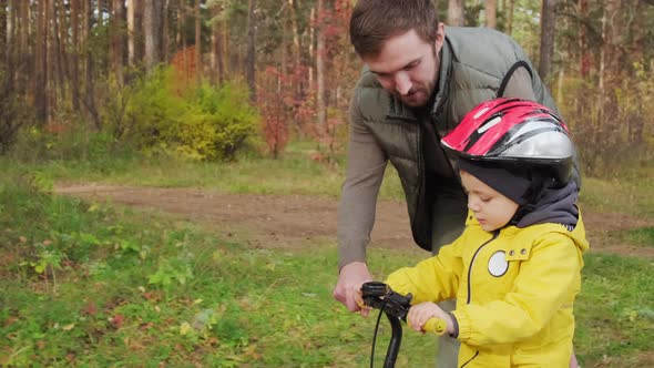 Slowmo of Father Teaching Son To Ride Balance Bike alt