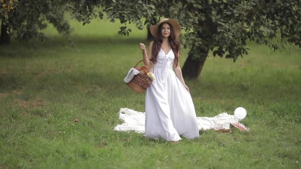 Gorgeous Woman with a Basket in Park.