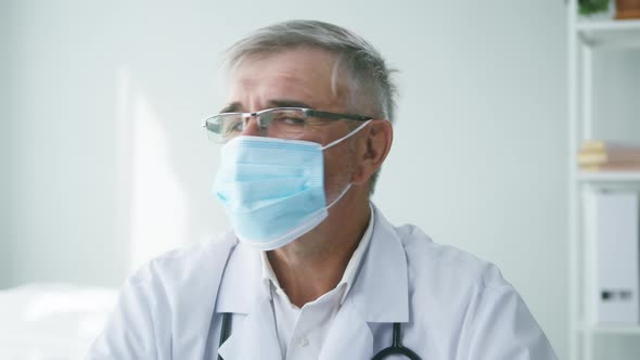 Elderly Grayhaired Doctor in Protective Mask Closeup Portrait of Male Therapist Wearing Glasses alt