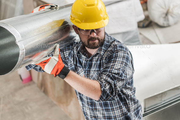Construction Worker Moving Pieces of HVAC System - Stock Photo - Images