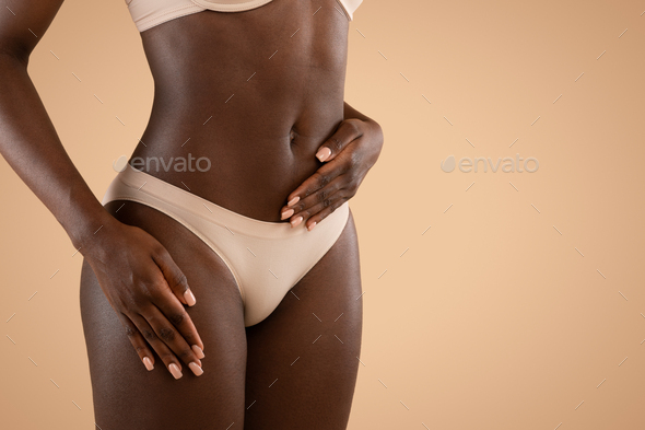 Cropped of black woman in underwear holding hand on belly Stock