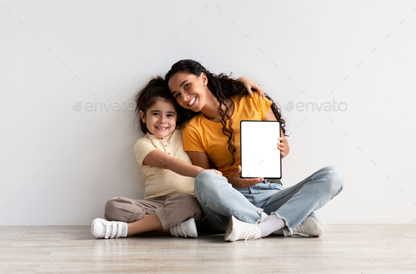 Online Ad. Happy Young Mother And Little Daughter Holding Blank Digital Tablet