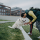 Side view of happy young man training his dog outdoors in city - PhotoDune Item for Sale