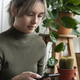 Woman carrying a cactus while checking her phone - PhotoDune Item for Sale