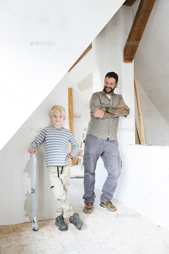 Portrait of smiling father and son working on loft conversion