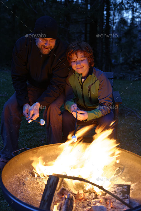 Father and son at the campfire roasting marshmallows