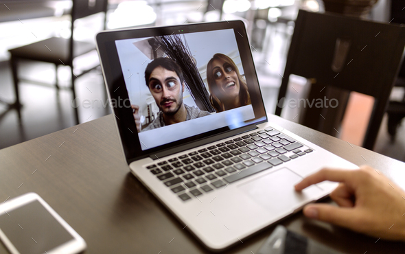 Funny photography of young couple on display of laptop